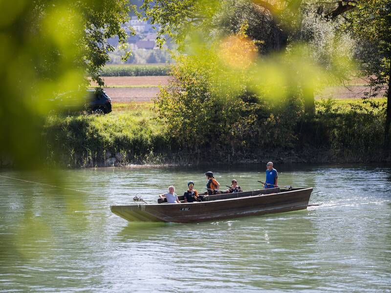 4 Personen und der Bootsmann fahren über den Rhein in einer alten Seilfähre