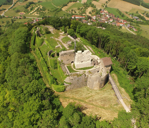 Luftbild der Ruine Küssaburg, umgeben von dichtem grünen Wald, im Hintergrund der Ortsteil Bechtersbohl