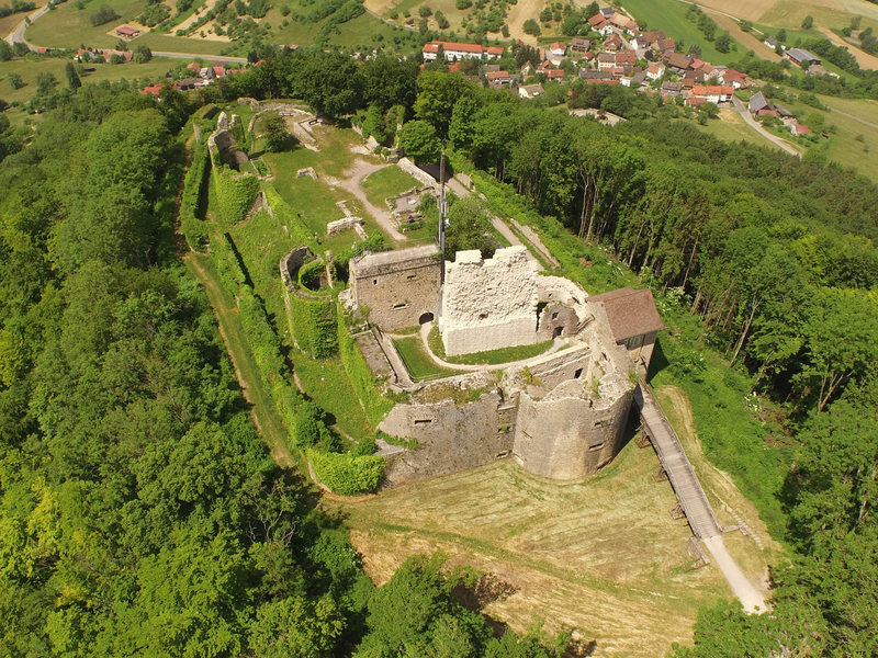 Luftbild der Ruine Küssaburg, umgeben von dichtem grünen Wald, im Hintergrund der Ortsteil Bechtersbohl