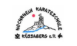 Das Bild zeigt ein Logo mit einer stilisierten Burg auf einem Hügel, einem roten Punkt darüber und der Aufschrift "Hochrhein Karateschule Küssaberg e.V.".