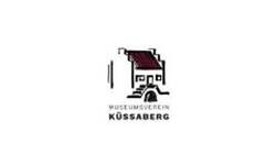 Das Bild zeigt das Logo des Museumvereins Küssaberg mit einer stilisierten Illustration eines Gebäudes mit Treppen und einem roten Dach.