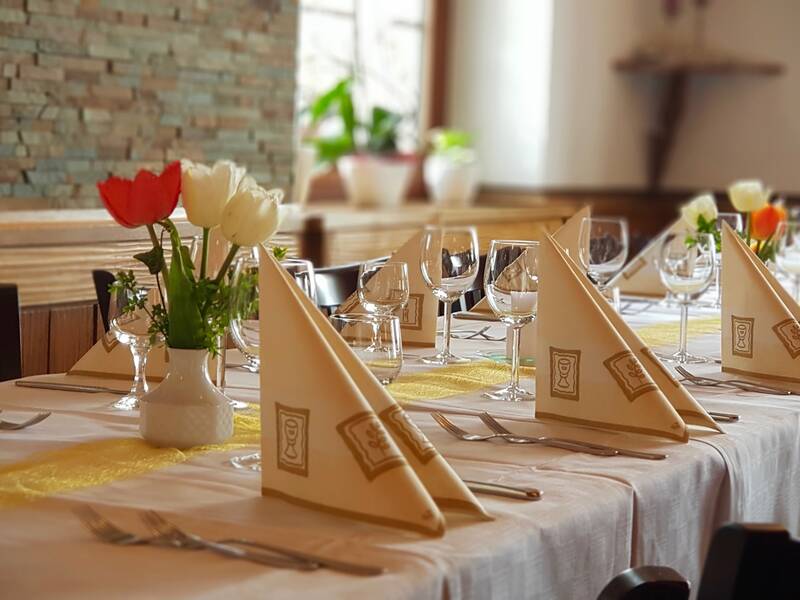 festlich gedeckter Tisch in einem Restaurant mit weißen und roten Tulpen